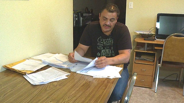 Clayton Boucher, 45, looks over court documents related to wrongful conviction recently in his North Battleford, Sask. home.