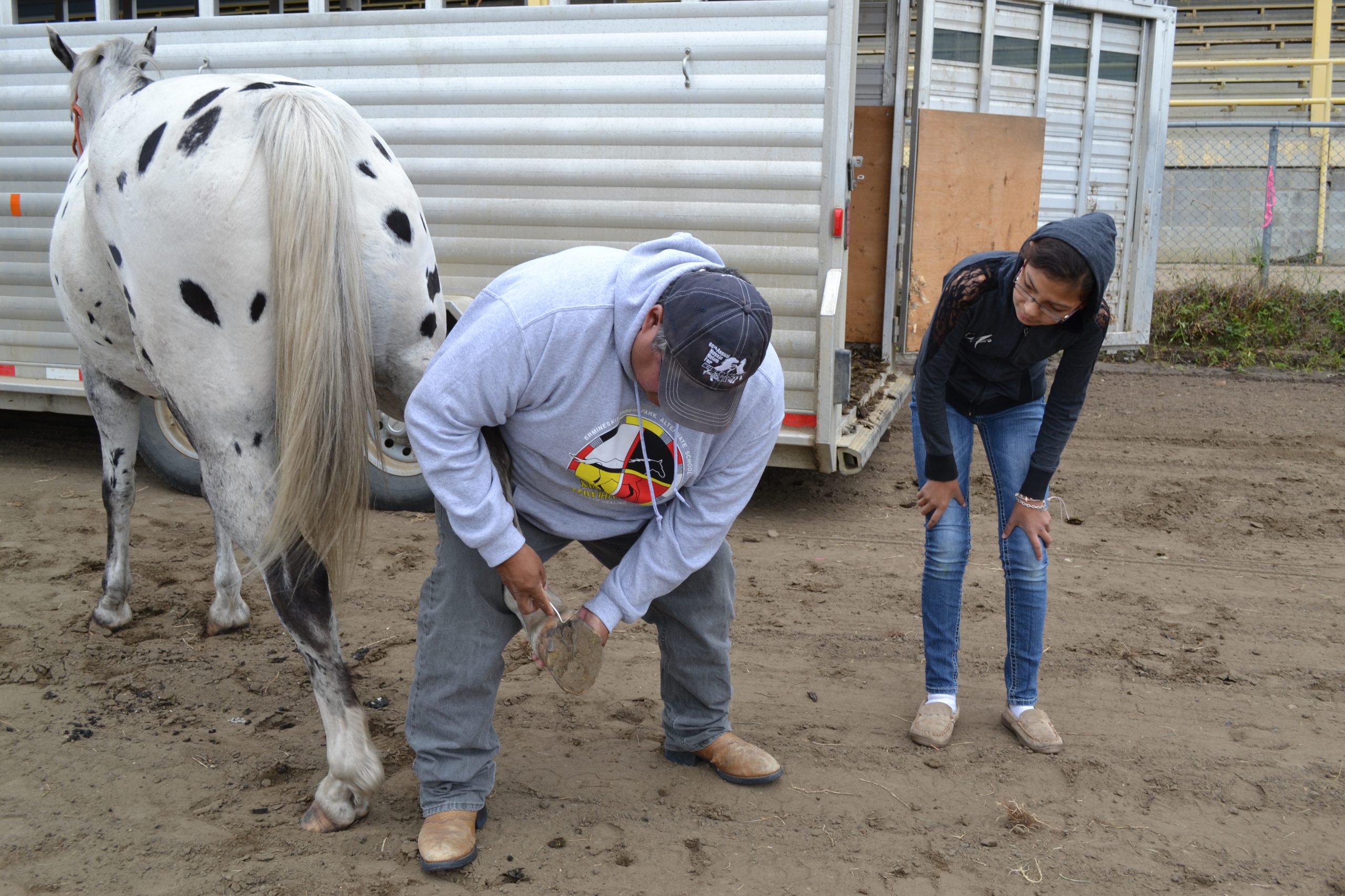 Warren Omeasoo shows Justise Wolf how to clean the hoofs of her horse. APTN/Photo
