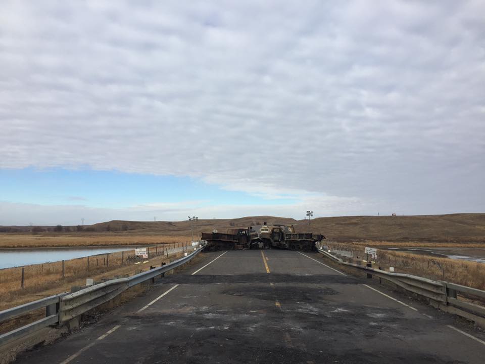 A photo of the two charred deuce-and-a-half at the barricade by Backwater Bridge photographed Saturday. Water protectors removed one of the trucks Sunday, sparking clash. Damian Joseph/APTN