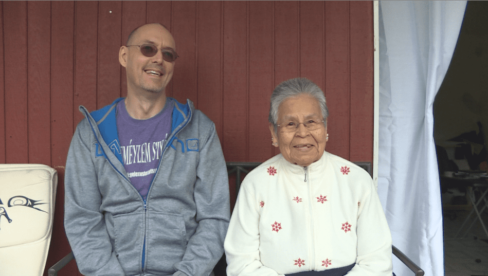 Strang Burton, a linguist, and Phillips sit outside of the elders home.